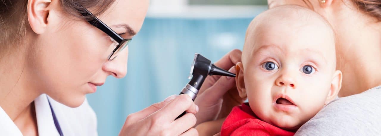 A child being examined by a doctor with an otoscope