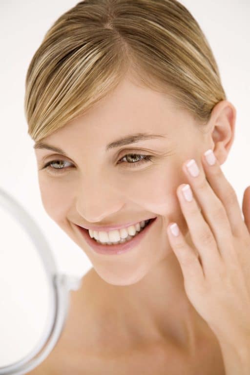 Woman smiling while looking in the mirror.