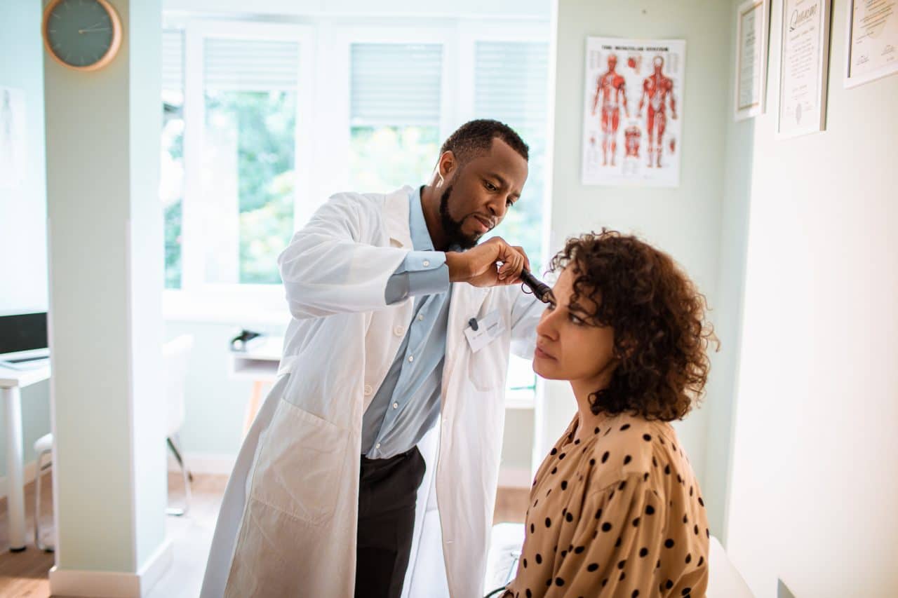 Woman gets an ear exam.