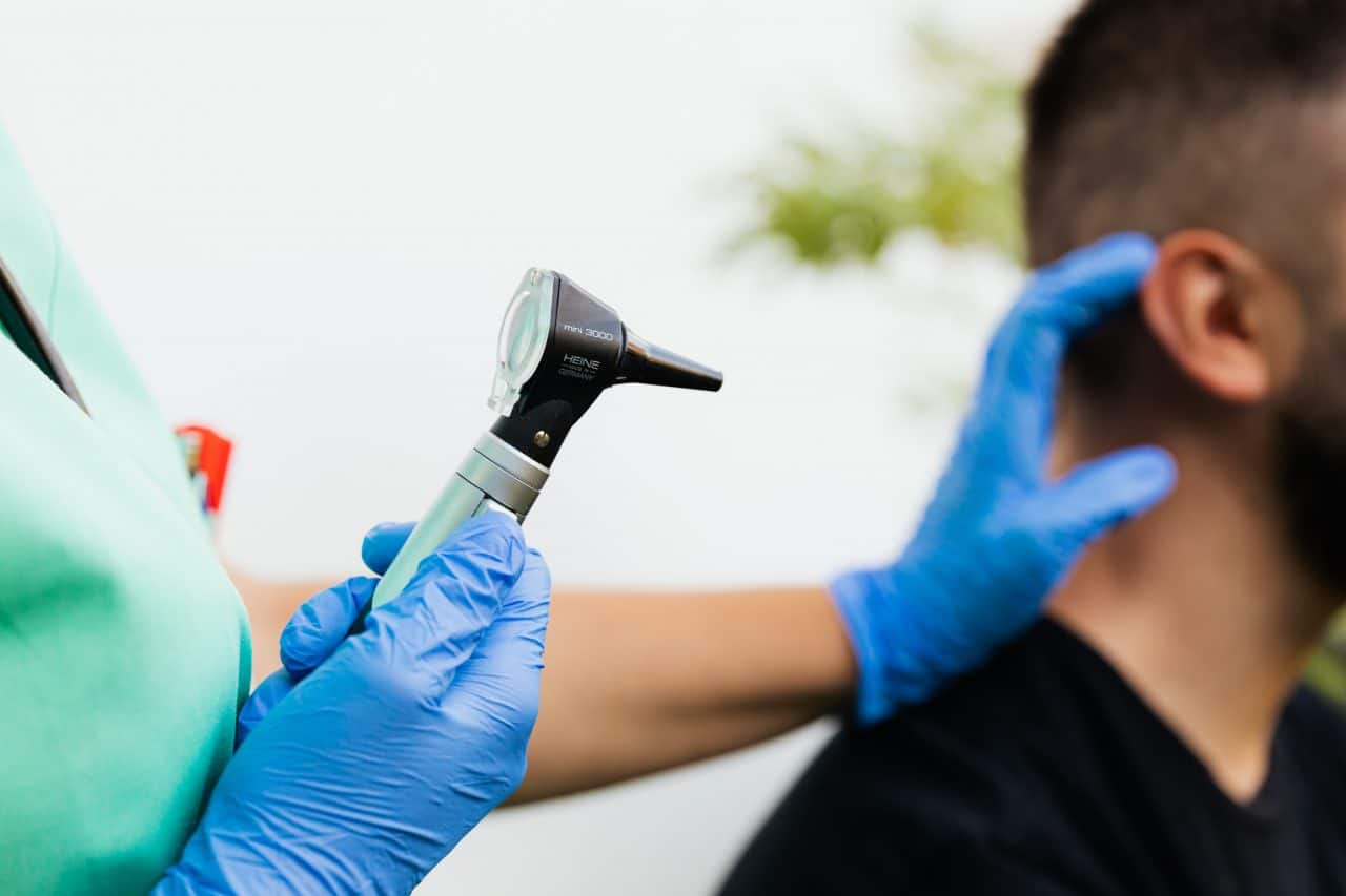 Doctor examining man with ear infection.