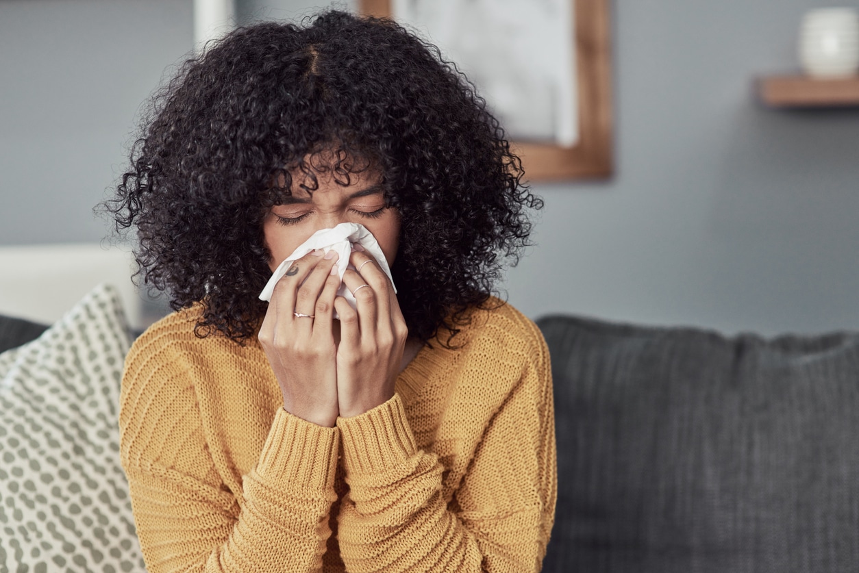 Woman sneezing due to allergies.